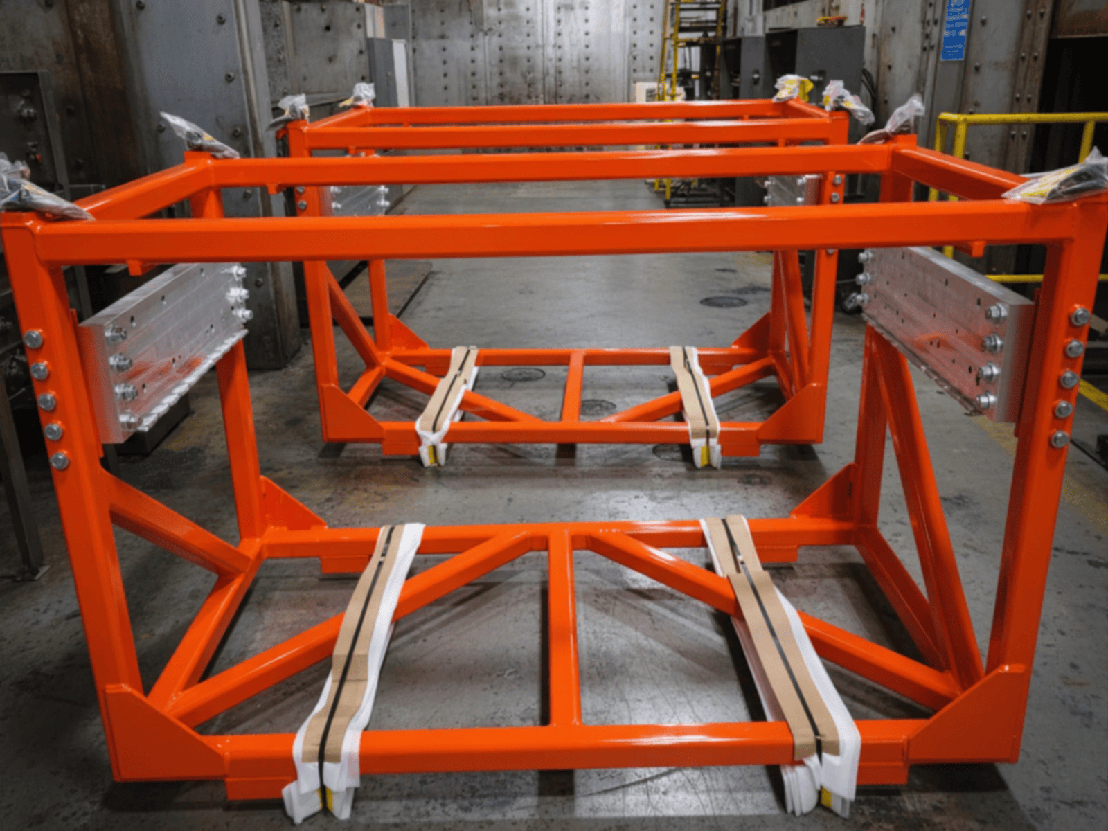Large fabricated and machined assemblies are loaded on a fork truck after receiving blue powder coating